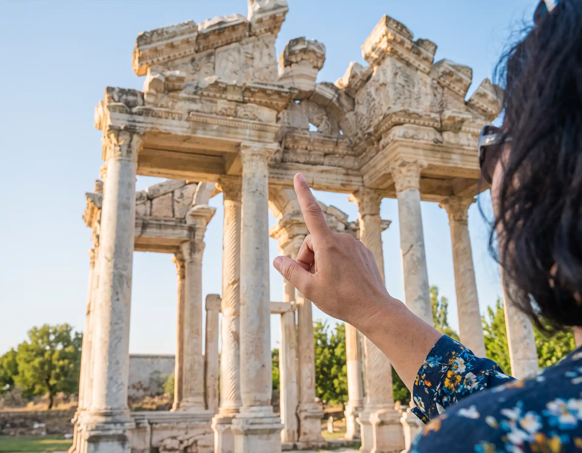 Guía local mostrando un detalle histórico en un tour por Grecia
